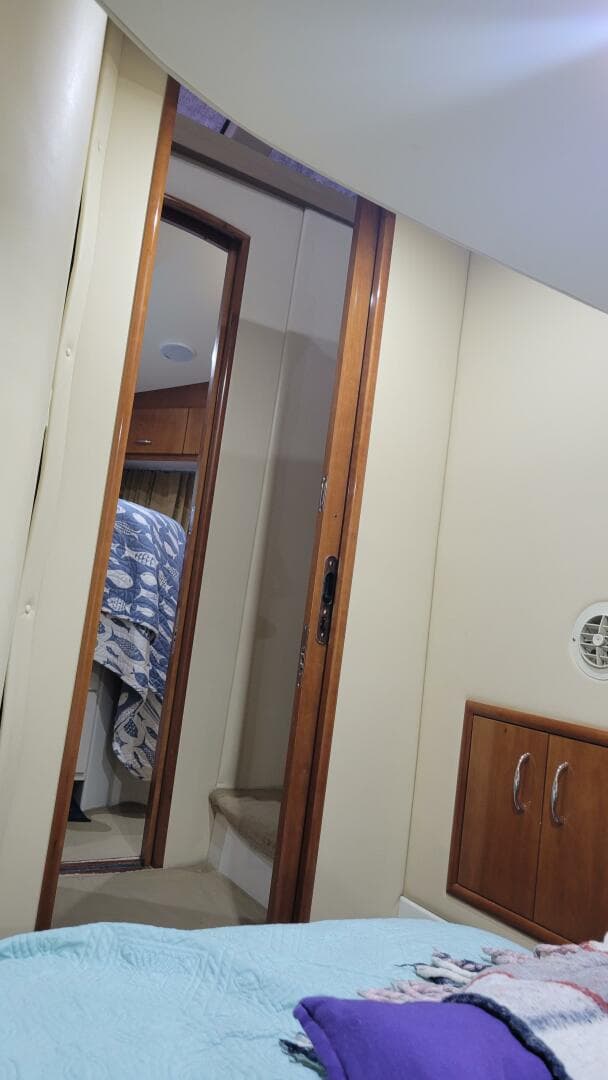 Interior of 2004 Carver 360 Sport Sedan with cozy bedroom and wooden cabinetry.