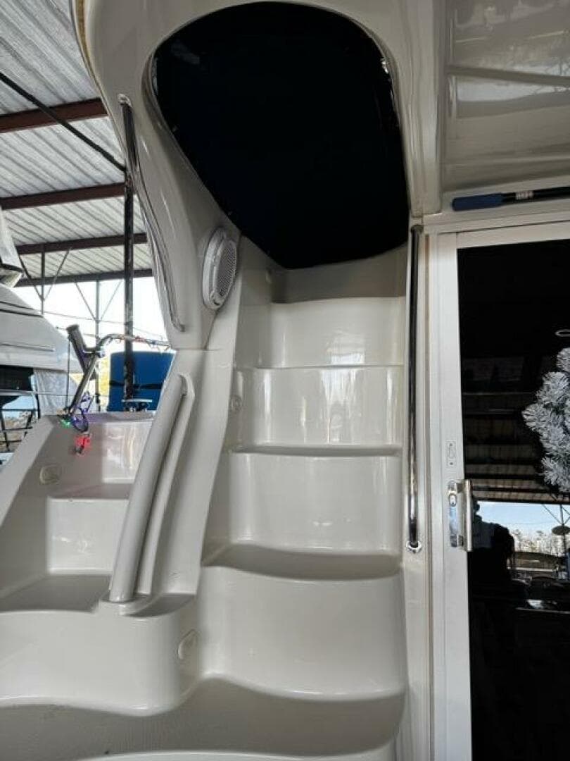 2004 Carver 360 Sport Sedan yacht interior stairs under a covered dock.