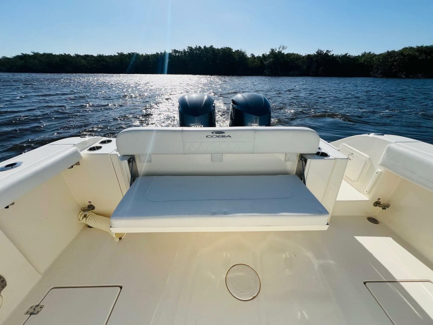 2021 Cobia 301 Center Console boat with dual engines on a sunny day.