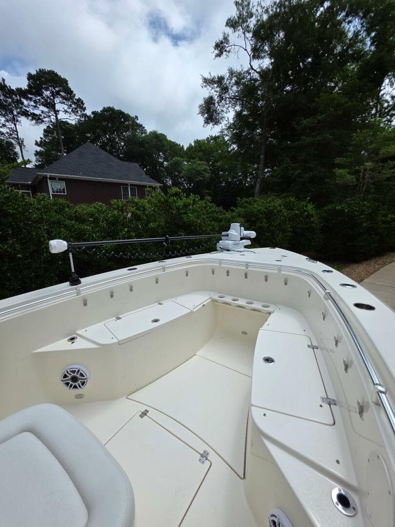 2021 Cobia 301 Center Console boat with spacious seating, surrounded by lush greenery.