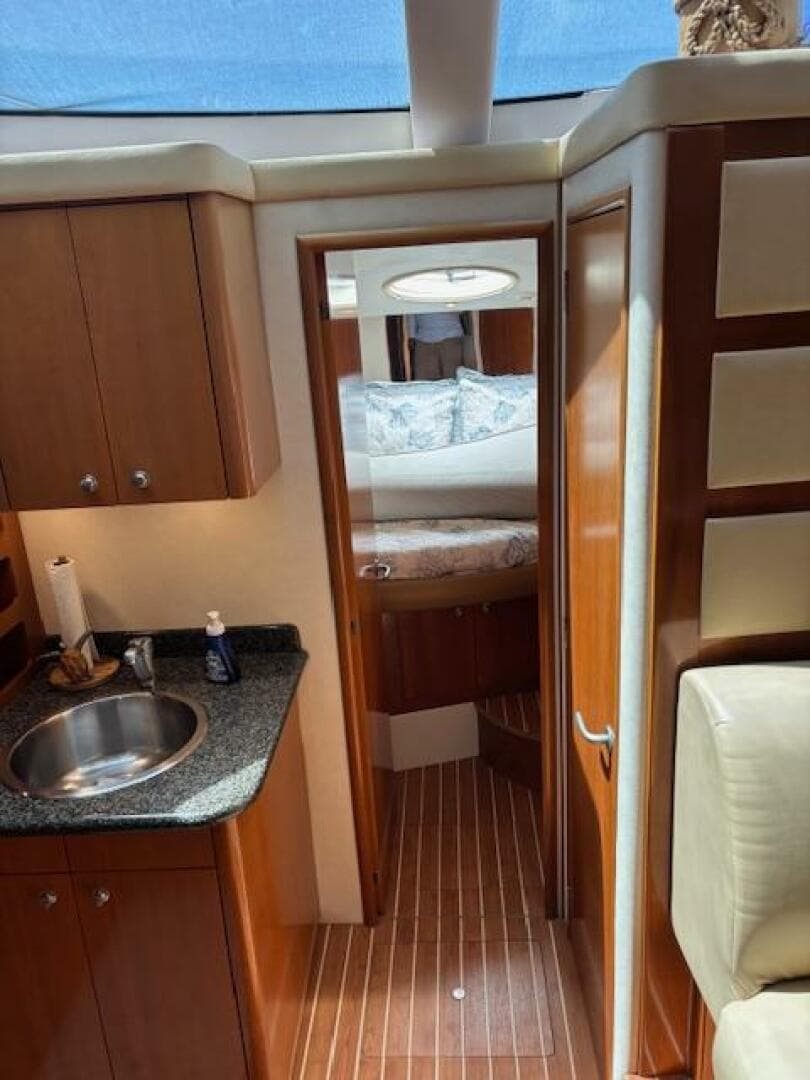 2006 Carver 43 Motor Yacht interior with wood cabinetry, sink, and cozy bedroom.