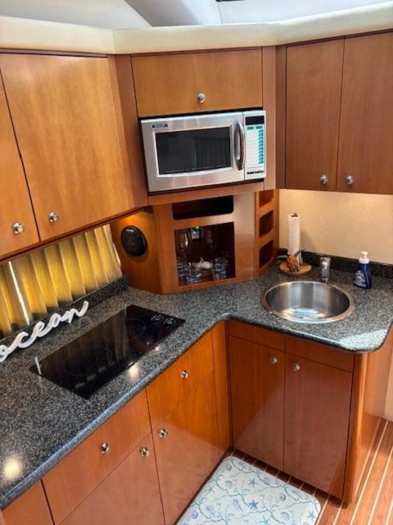 2006 Carver 43 Motor Yacht kitchen with microwave, sink, and stovetop.