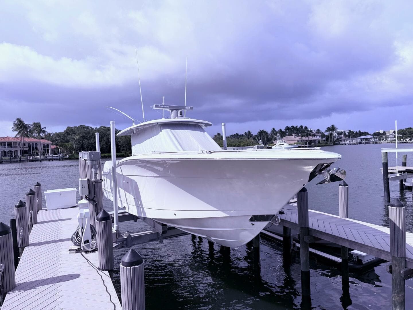 2024 Scout 400 LXF boat docked at marina under cloudy sky.