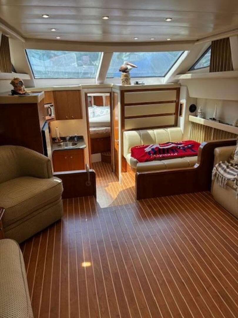 Interior of 2006 Carver 43 Motor Yacht with wood flooring and cozy seating area.