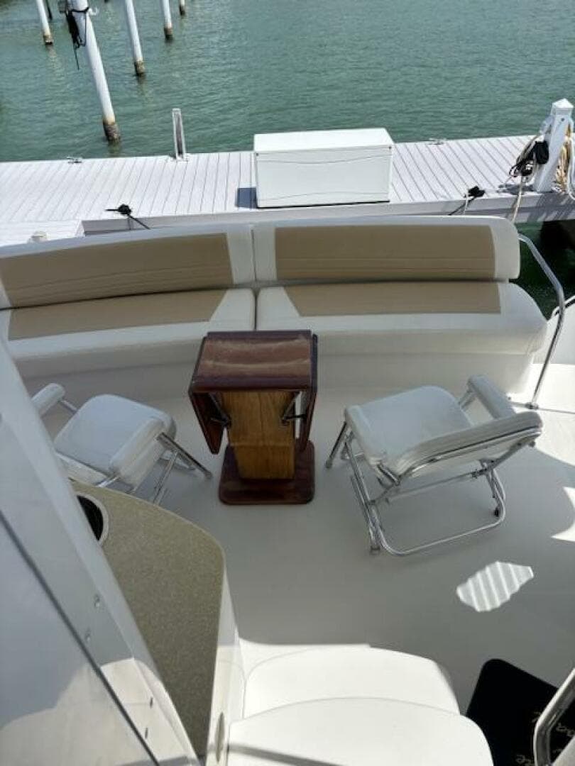 2006 Carver 43 Motor Yacht deck with seating and table, docked by the water.