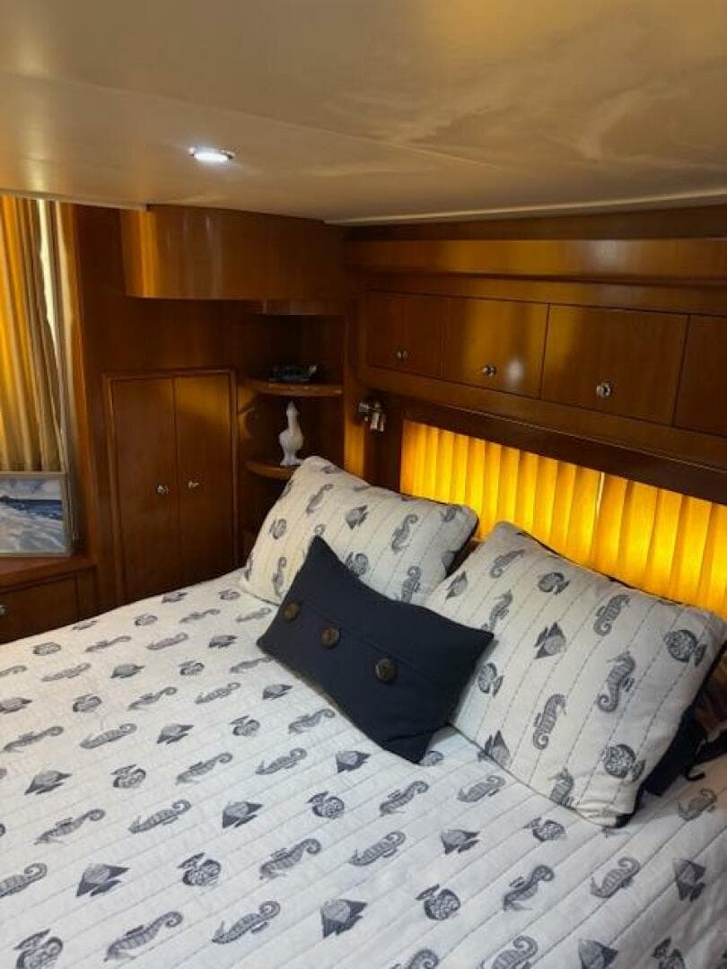 Luxurious bedroom interior of 2006 Carver 43 Motor Yacht with elegant bedding and warm lighting.