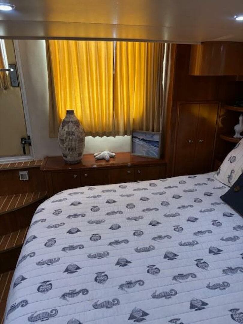 Cozy bedroom interior of 2006 Carver 43 Motor Yacht with nautical-themed bedding.