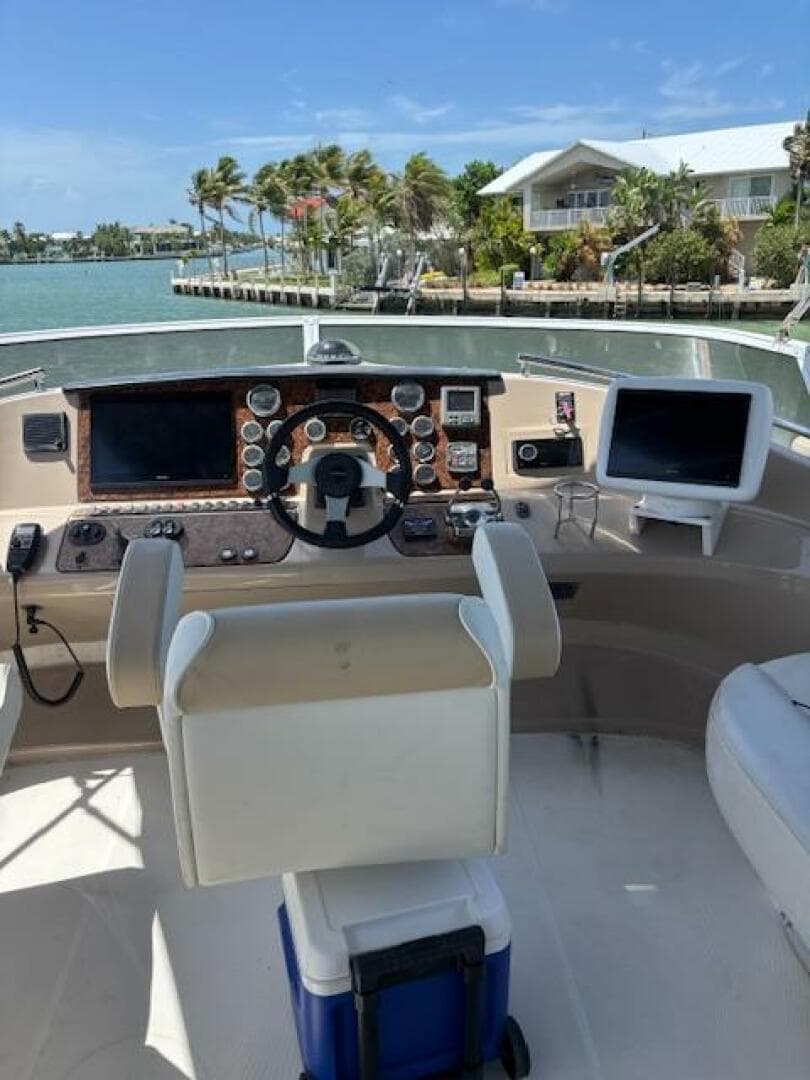 Helm of 2006 Carver 43 Motor Yacht with navigational equipment, overlooking a scenic waterfront.