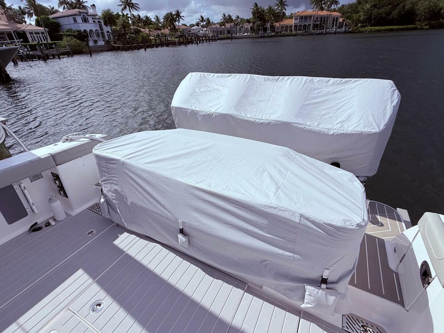 2024 Scout 400 LXF boat with covered engines docked by waterfront homes.