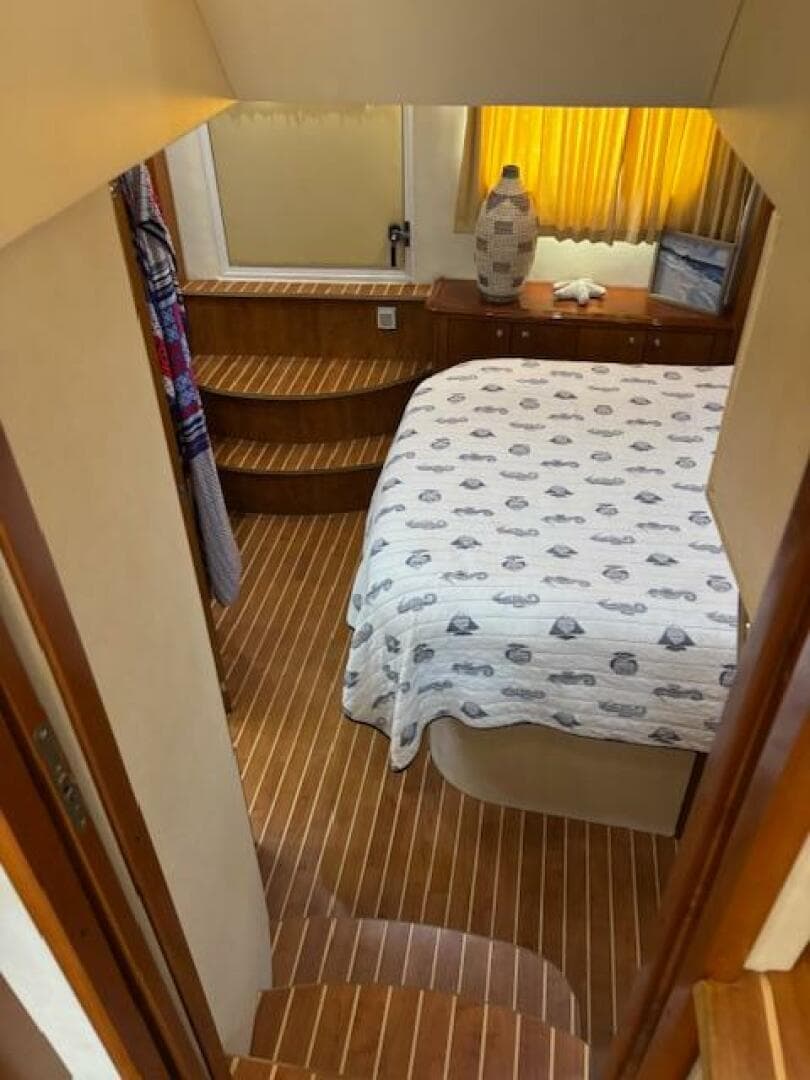 Interior of 2006 Carver 43 Motor Yacht with cozy bedroom and wooden flooring.