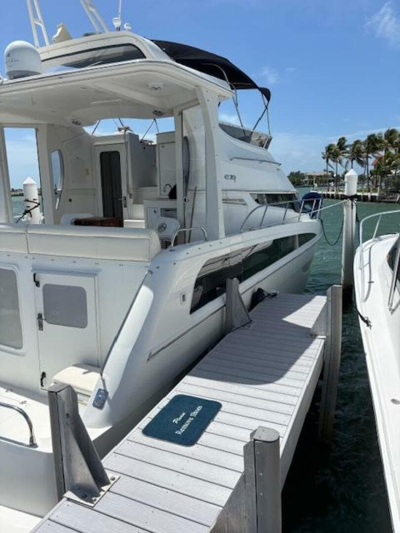 2006 Carver 43 Motor Yacht docked at marina, sunny day, clear skies, palm trees in background.