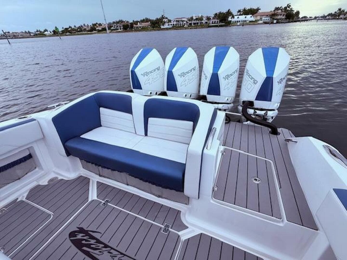 2022 Nor-Tech 390 Sport Center Console boat with quad engines and stylish seating on calm water.