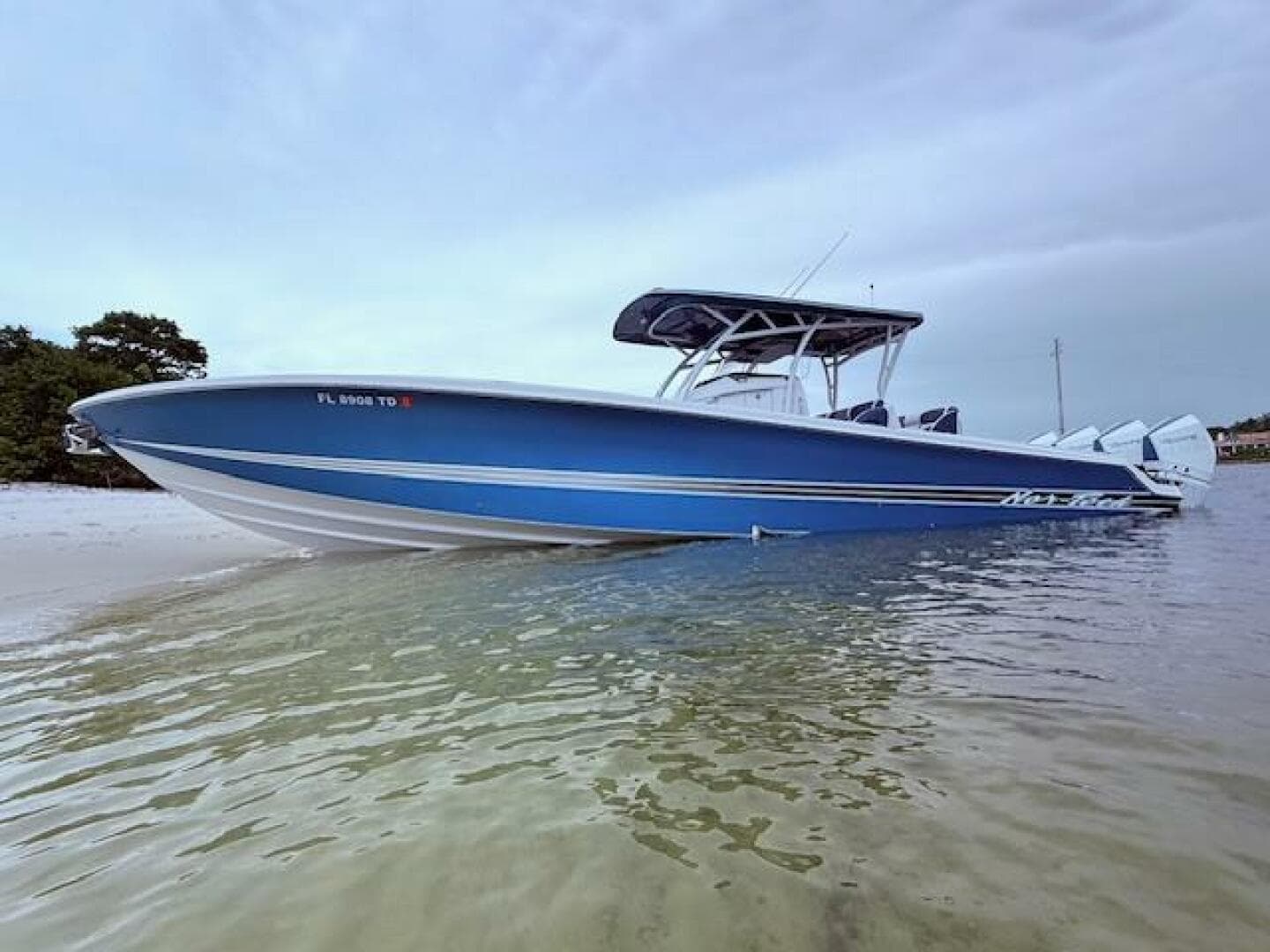 2022 Nor-Tech 390 Sport Center Console boat in shallow water, showcasing sleek blue design.