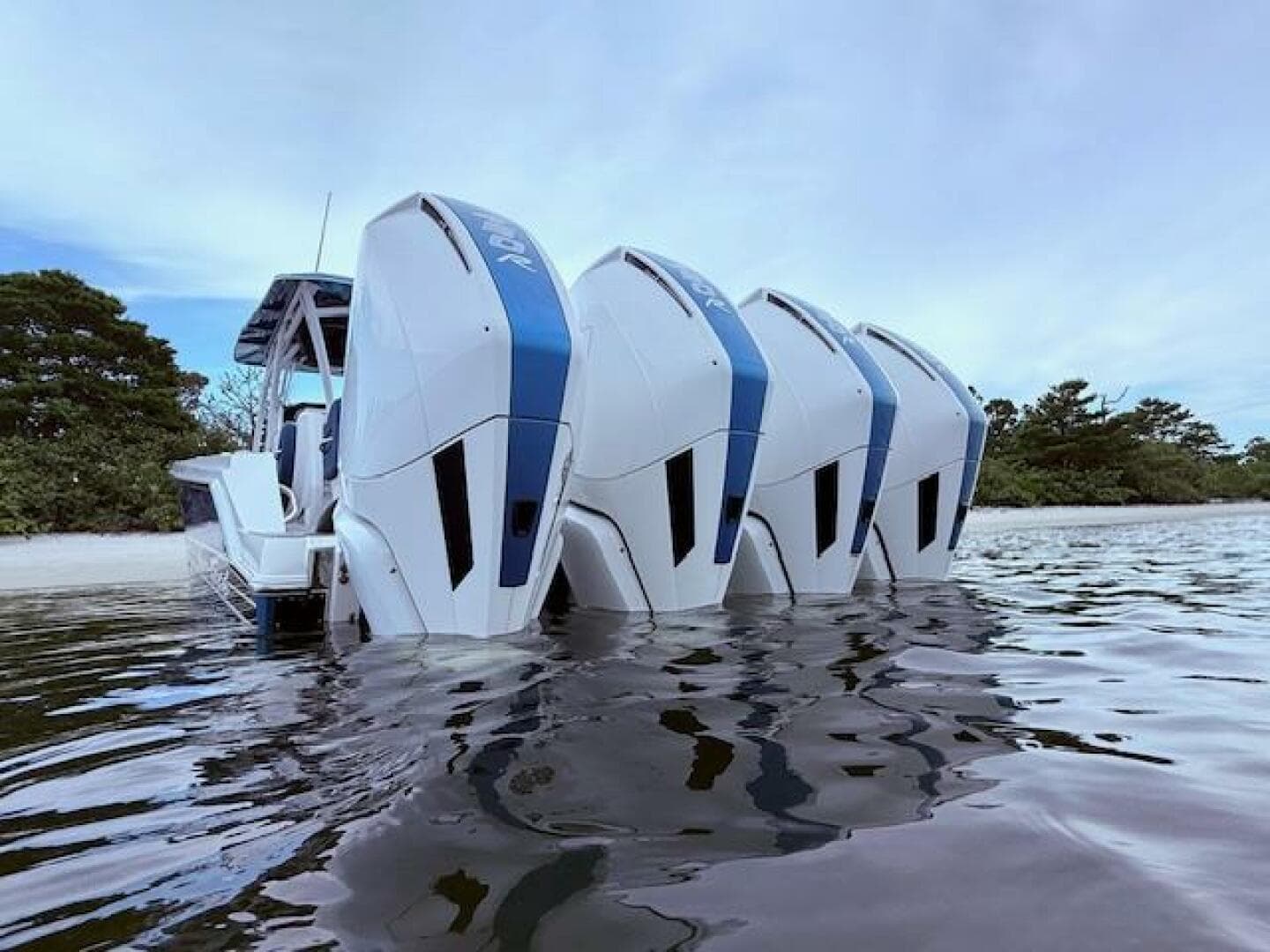 2022 Nor-Tech 390 Sport Center Console with four powerful outboard engines in calm water.