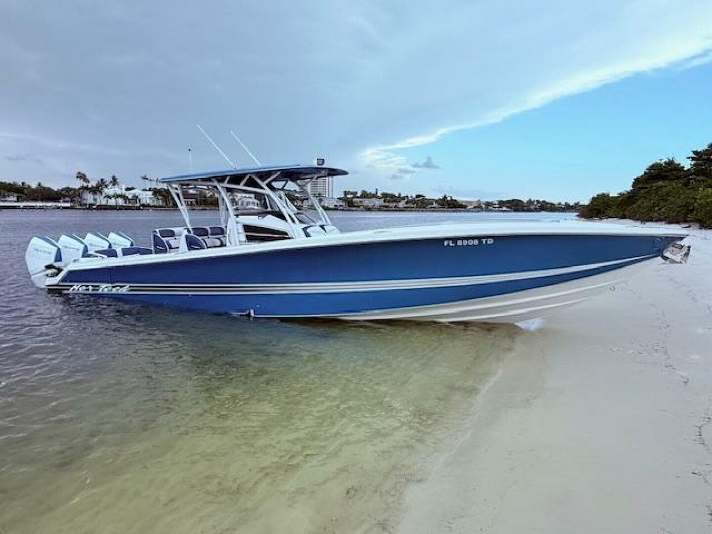 2022 Nor-Tech 390 Sport Center Console boat beached on sandy shore, featuring sleek blue design.