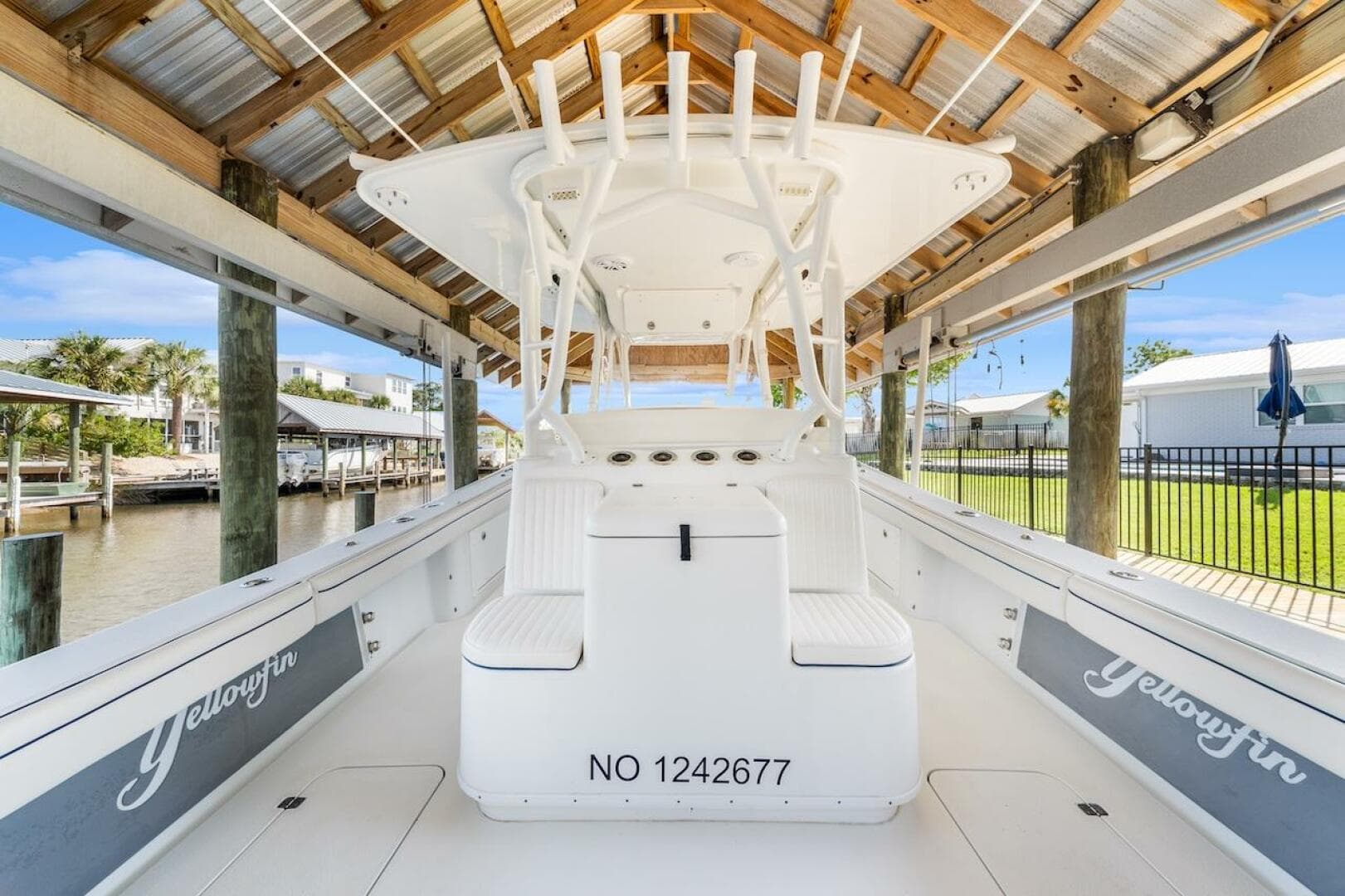 2015 Yellowfin 39 boat docked under a wooden canopy, showcasing sleek design and spacious seating.