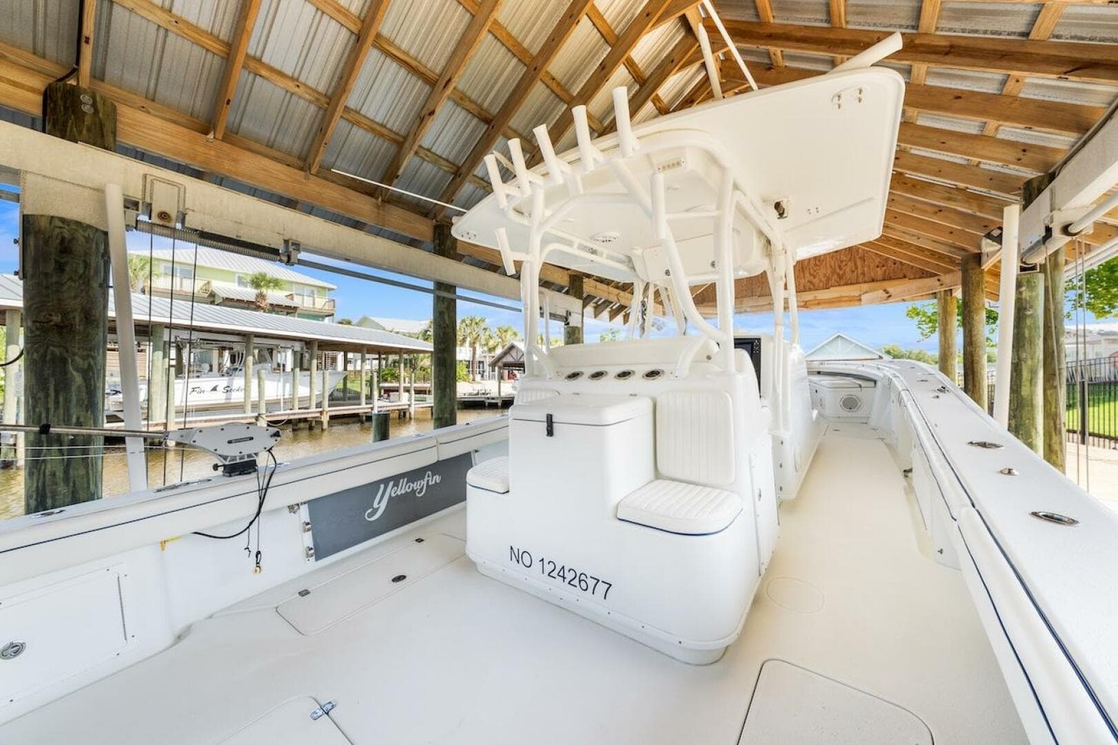 2015 Yellowfin 39 boat docked under a wooden shelter.