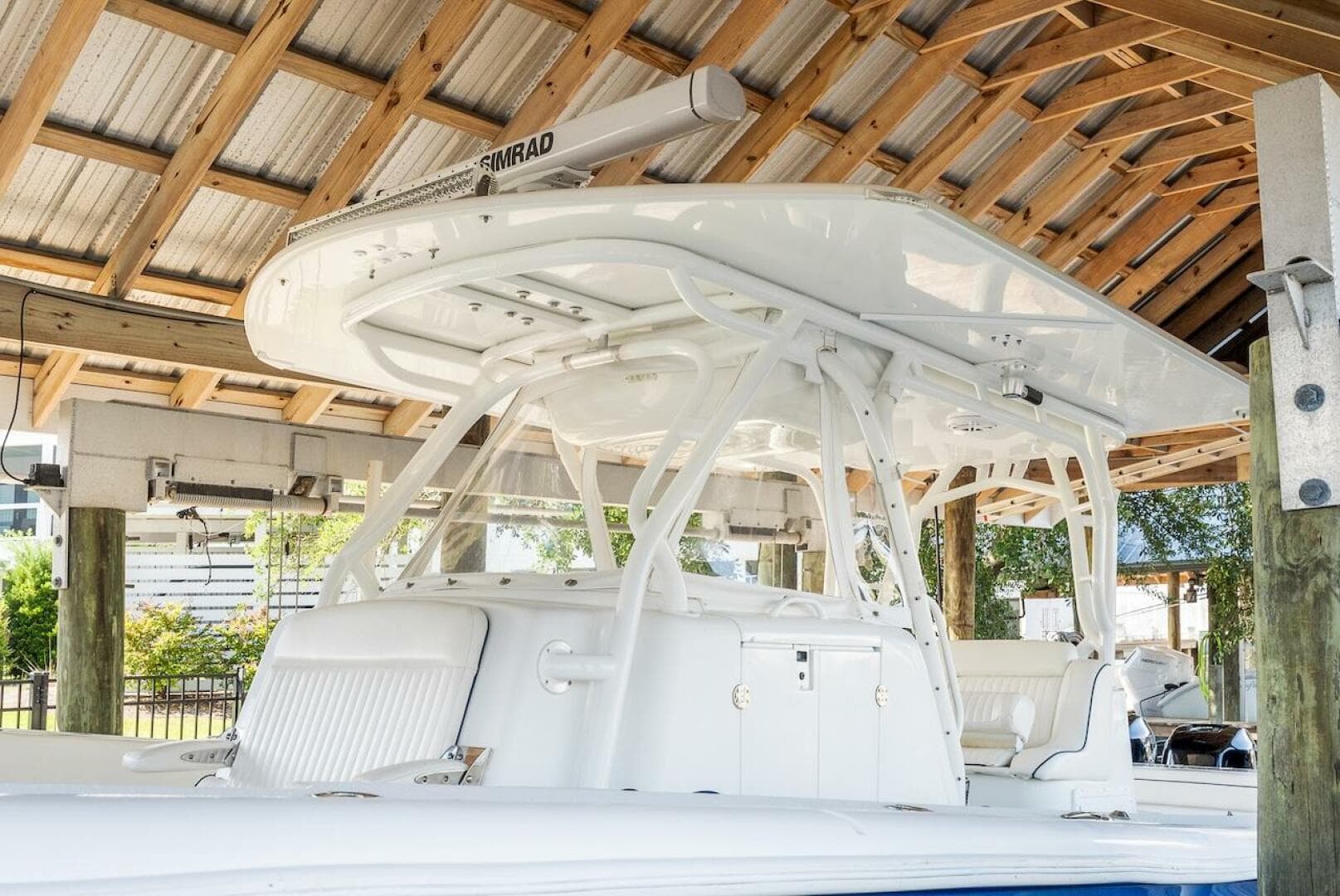 2015 Yellowfin 39 boat under wooden shelter, featuring sleek white design and advanced equipment.