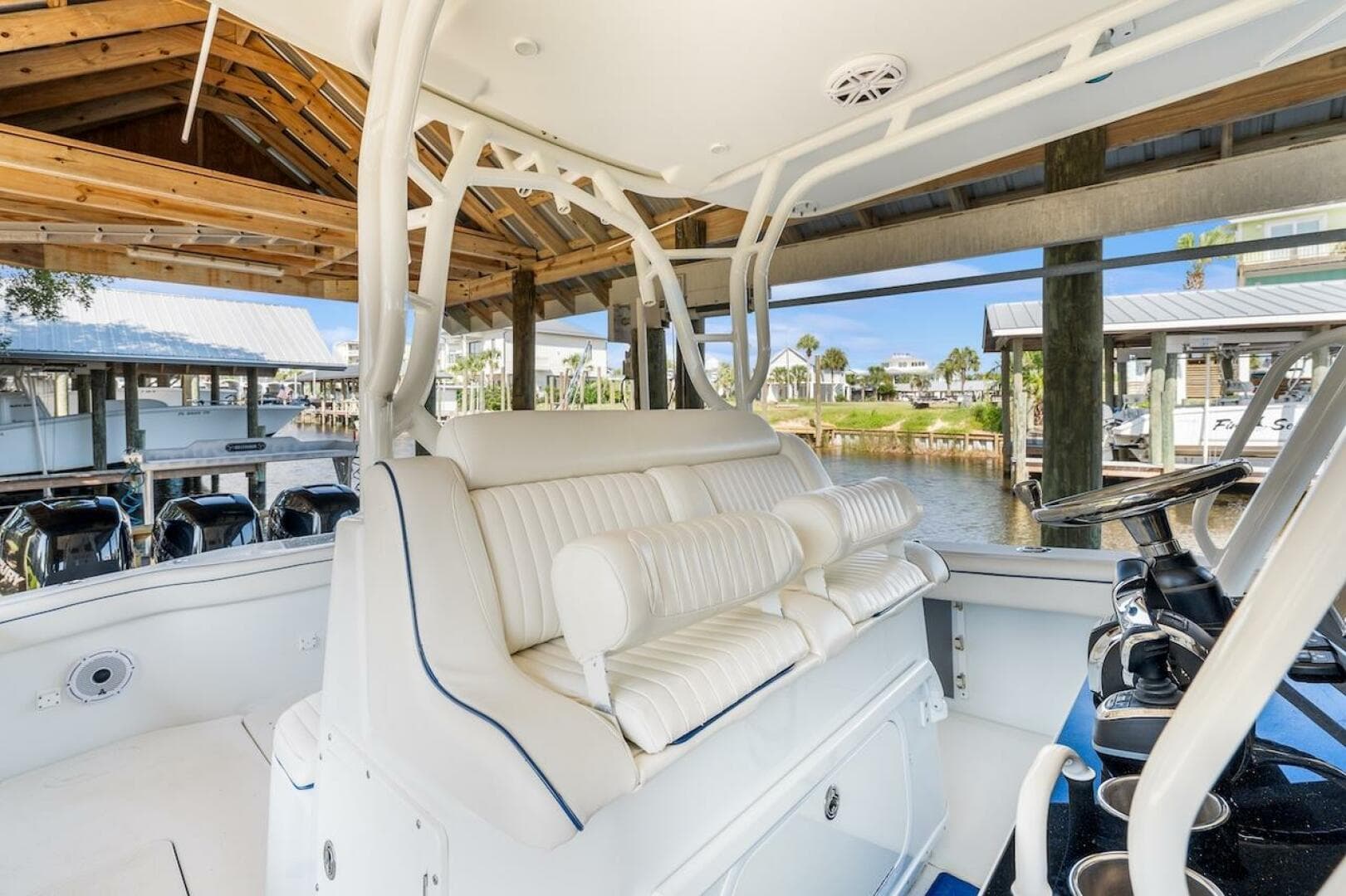 2015 Yellowfin 39 boat interior with white seating, docked under a wooden shelter.