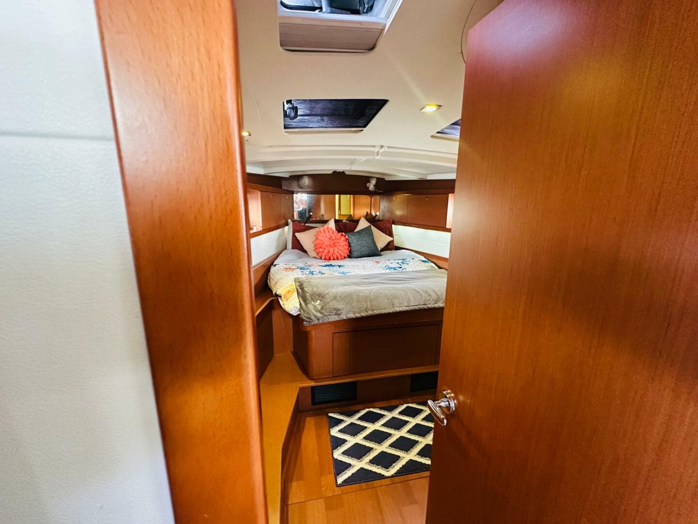 Cozy cabin interior of 2015 Beneteau Oceanis 45 sailboat with bed and wooden finish.