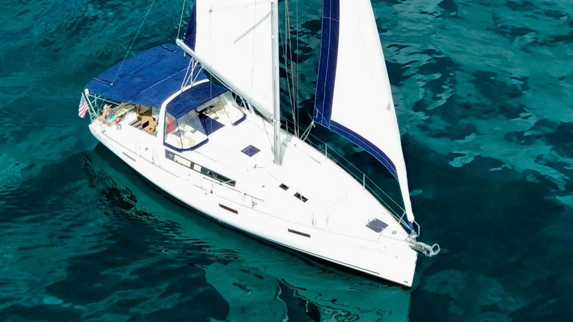 2015 Beneteau Oceanis 45 sailing on clear blue water.