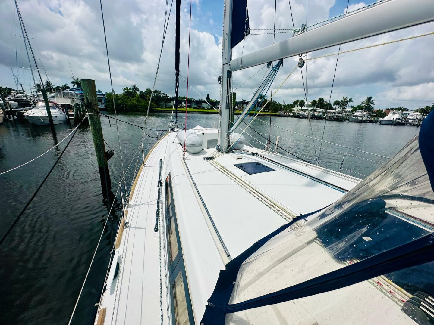 Beneteau Oceanis 45 sailboat docked in a marina, 2015 model, under cloudy skies.