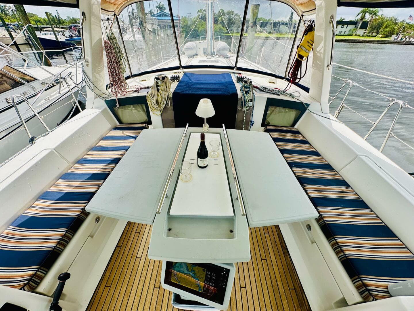 Cockpit of 2015 Beneteau Oceanis 45 with striped seating and table setup.