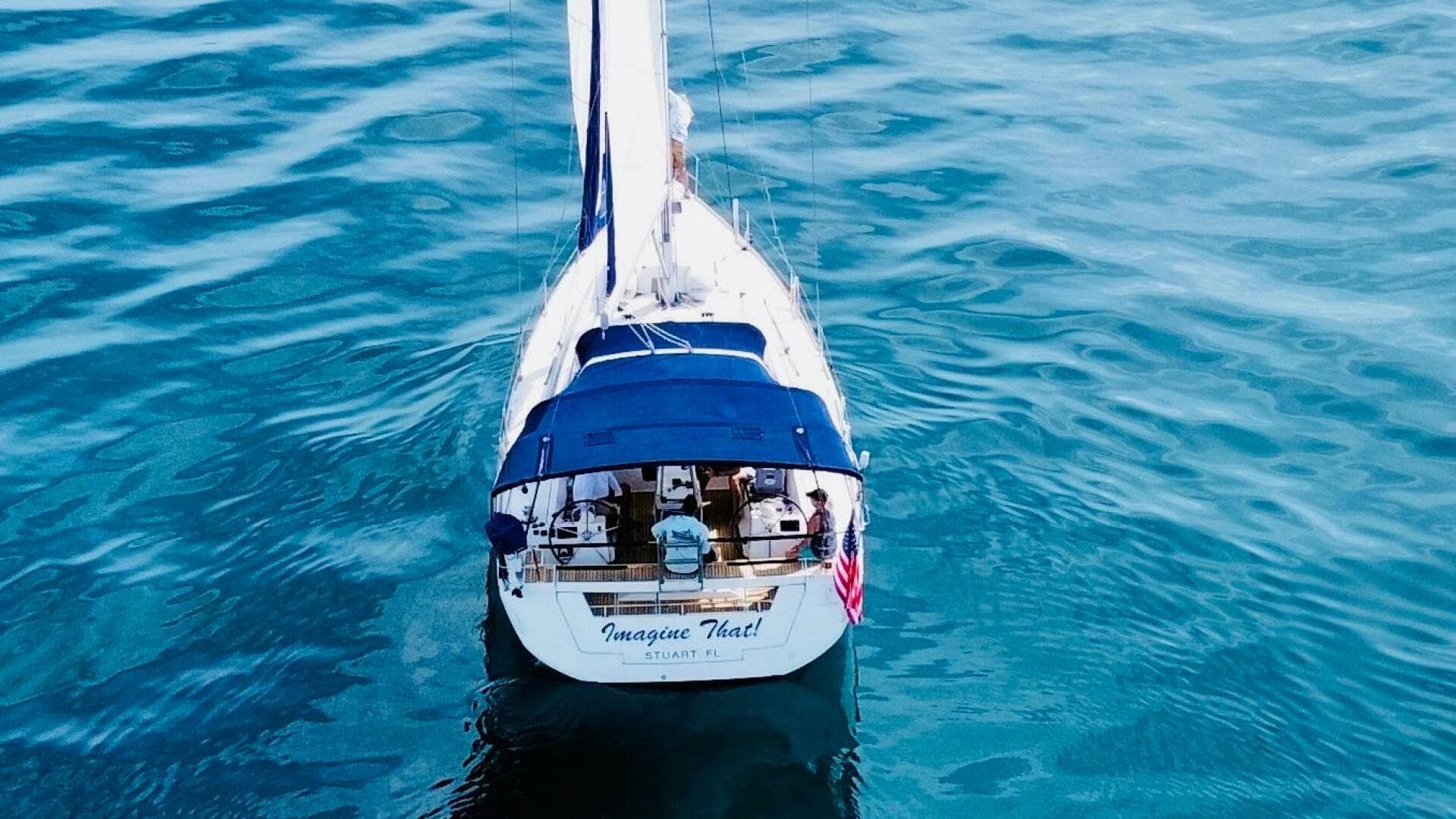 Beneteau Oceanis 45 sailboat on calm blue water, aerial view, 2015 model.