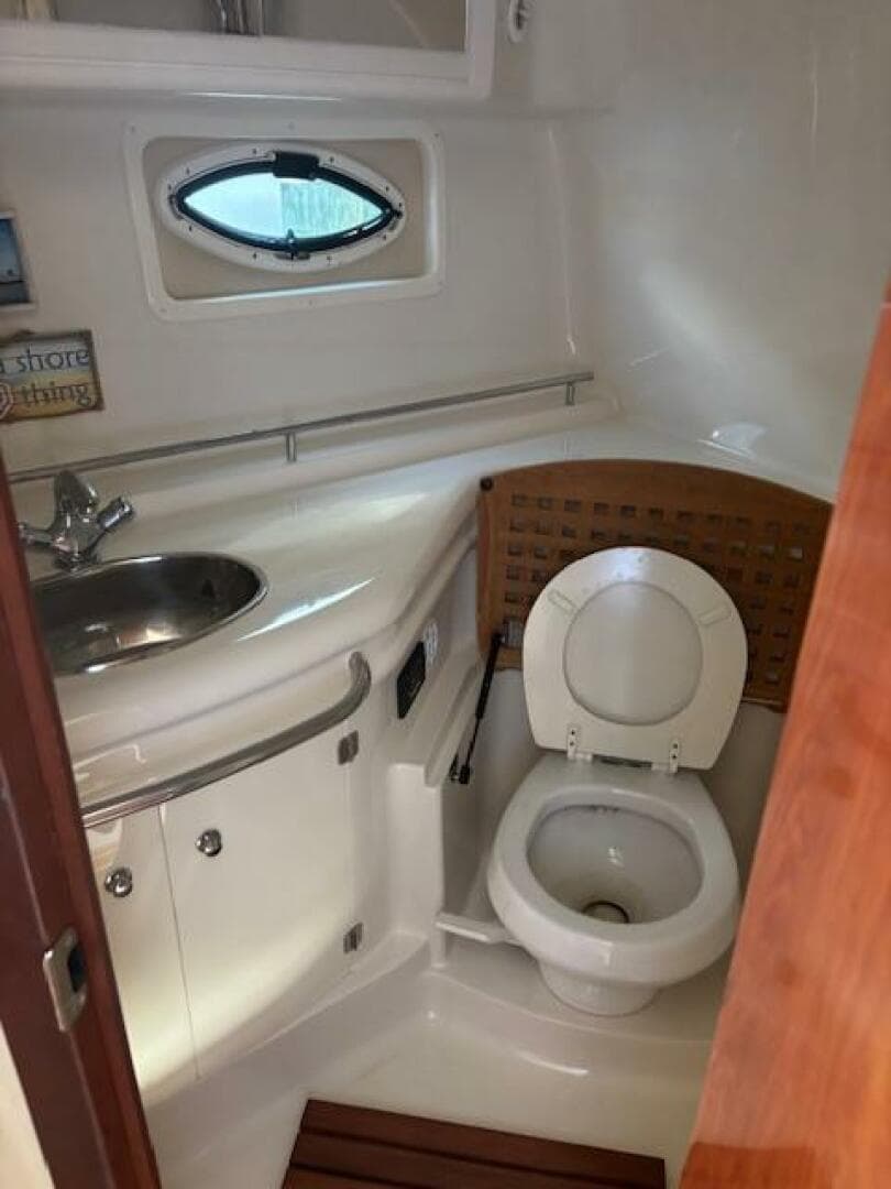 2007 Monterey 350 Sport Yacht bathroom with sink, toilet, and porthole window.
