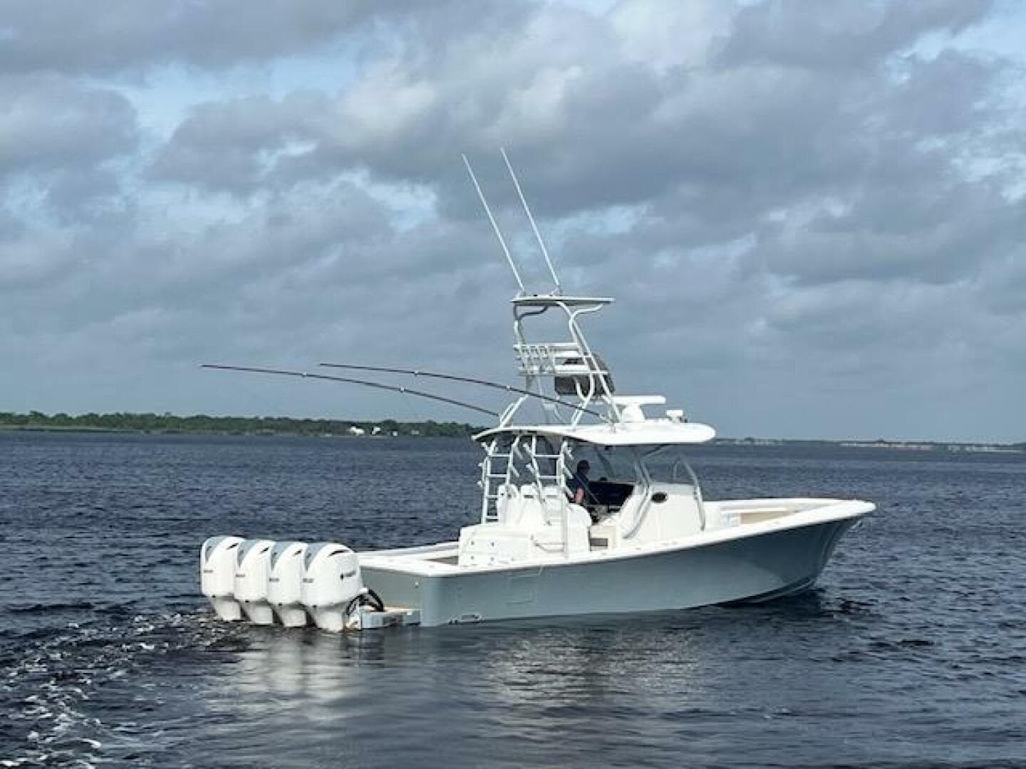 2018 Regulator 41 boat with four engines cruising on open water under cloudy skies.