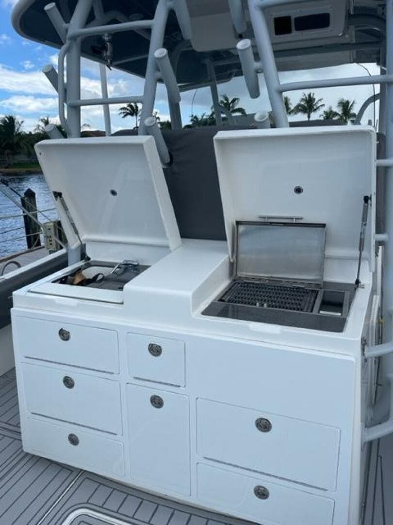 2018 Regulator 41 boat with open storage compartments and grill on deck.