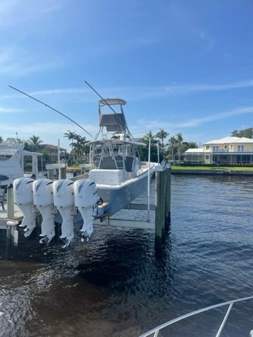2018 Regulator 41 boat docked with four outboard engines, under a clear blue sky.