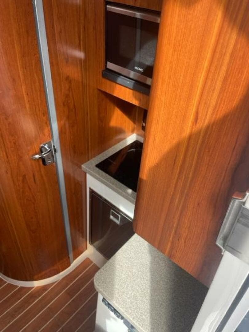 2018 Regulator 41 interior with wood finish, compact kitchen, and modern appliances.