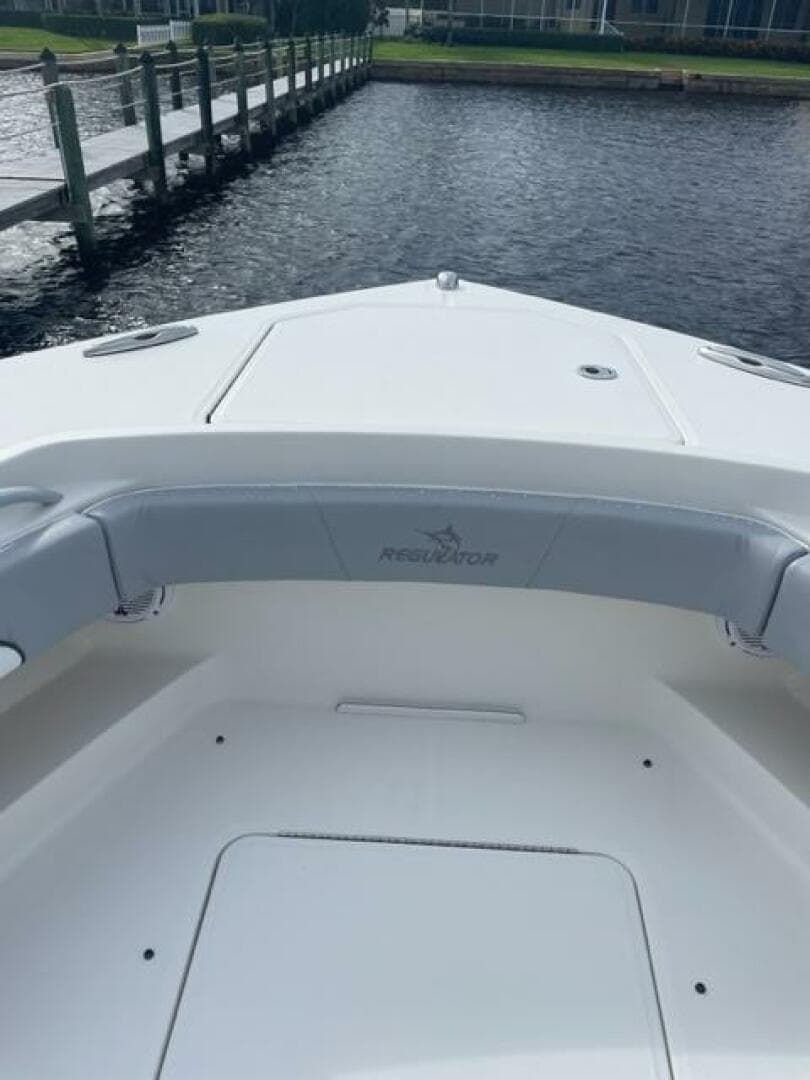 2018 Regulator 41 boat bow with seating, docked by a wooden pier.