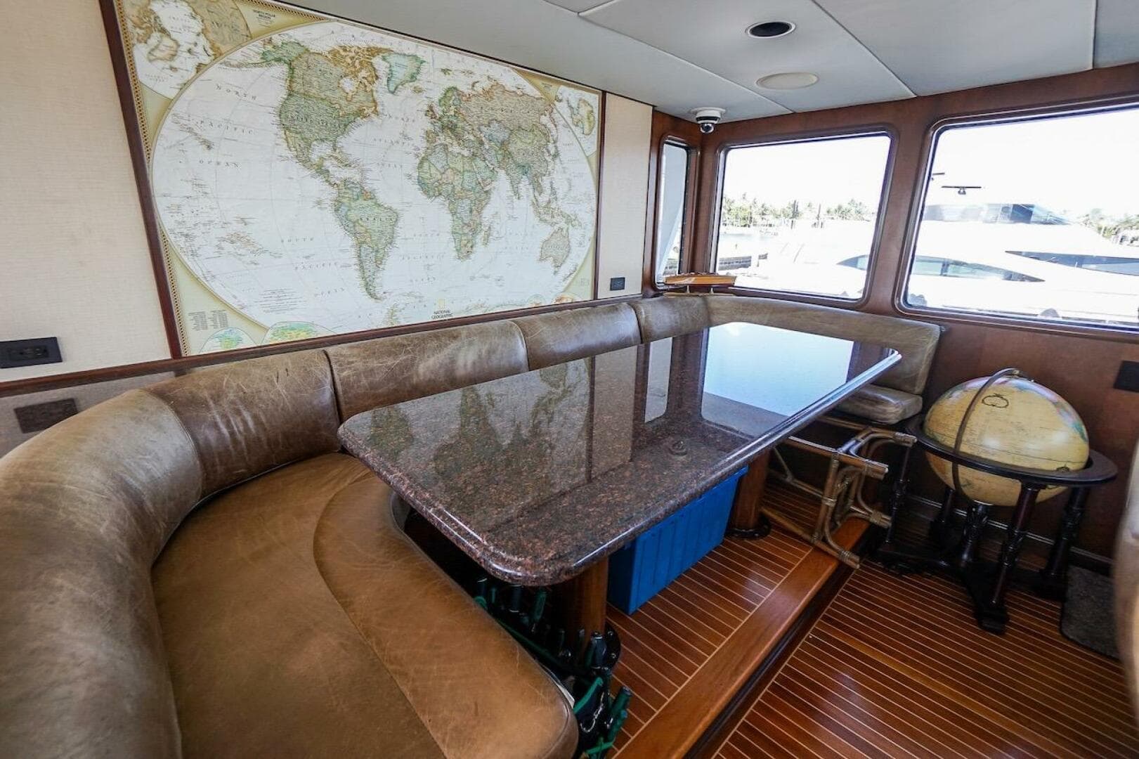 Luxury yacht deck with three white chairs, overlooking marina and waterfront buildings. ABD 90 Explorer, 1996.