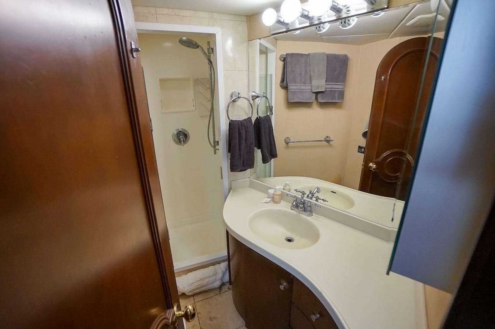 Compact bathroom in 1996 ABD 90 Explorer with shower, sink, and mirror.