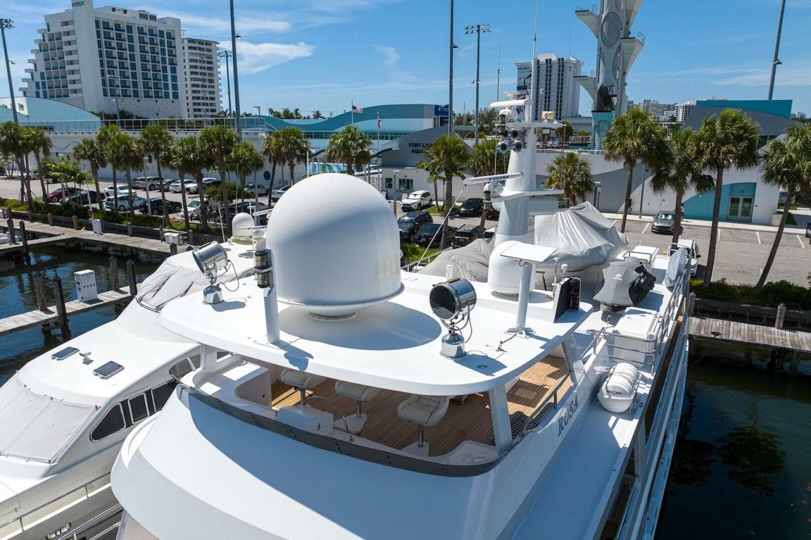 Luxury yacht docked at marina, ABD 90 Explorer, 1996 model, sunny day, palm trees nearby.