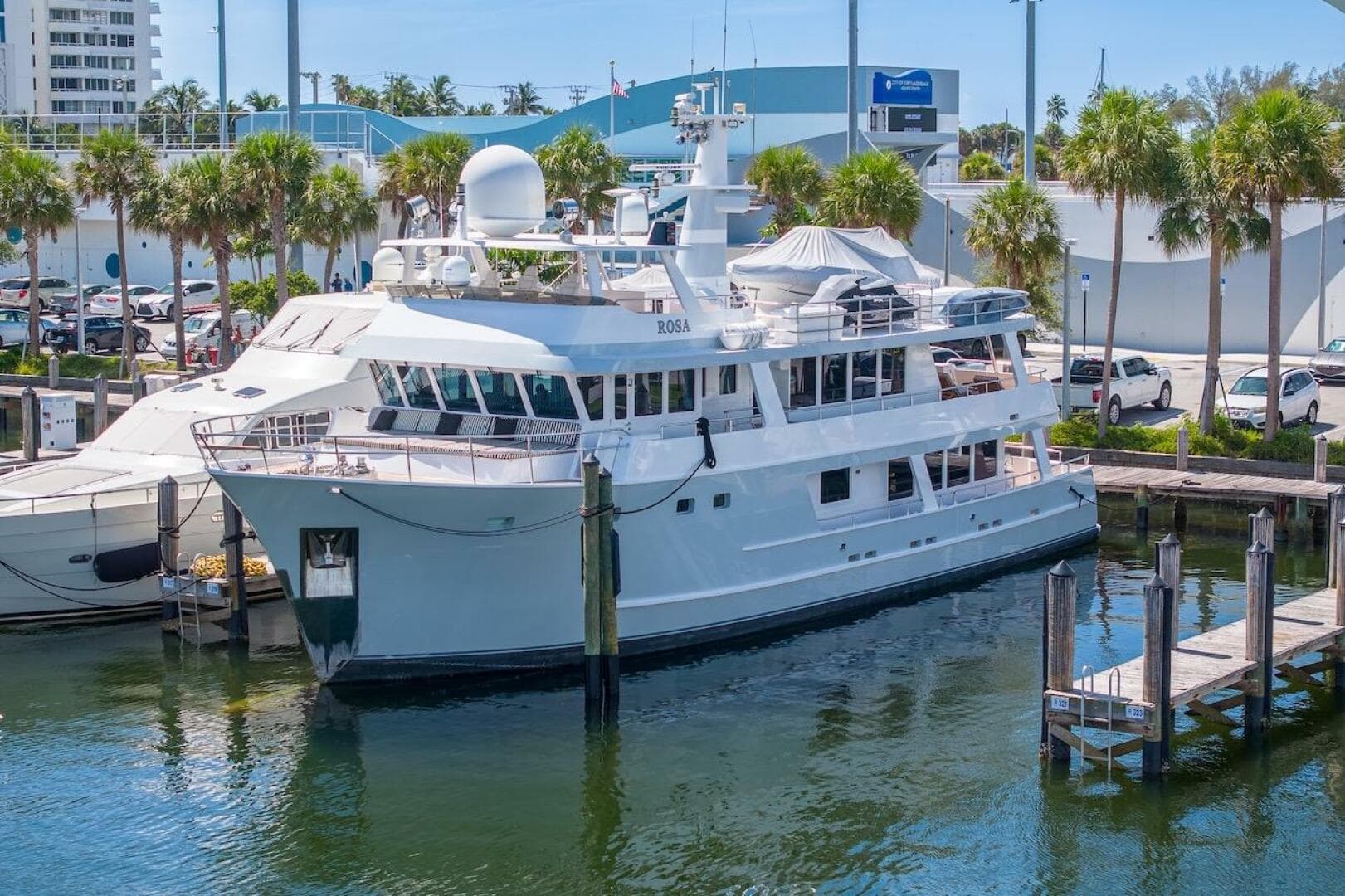 Luxury yacht ABD 90 Explorer 1996 docked at marina with palm trees.