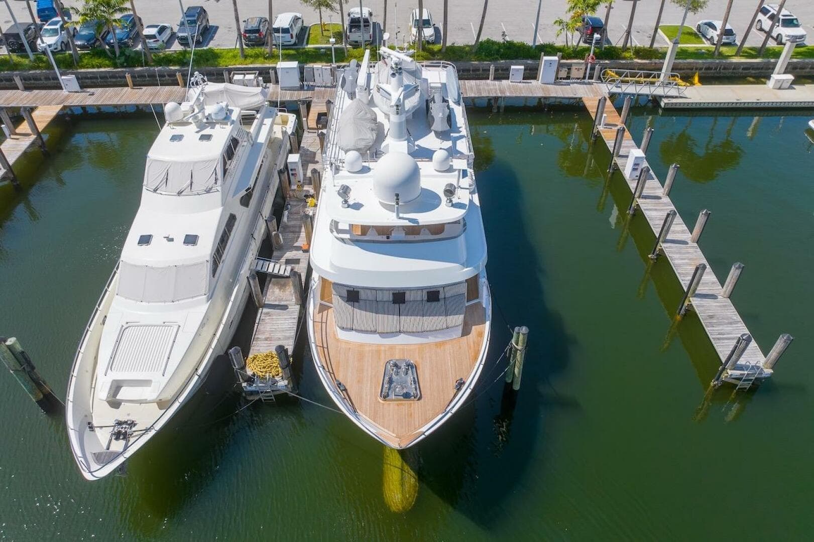 Two luxury yachts docked at a marina, featuring the 1996 ABD 90 Explorer.