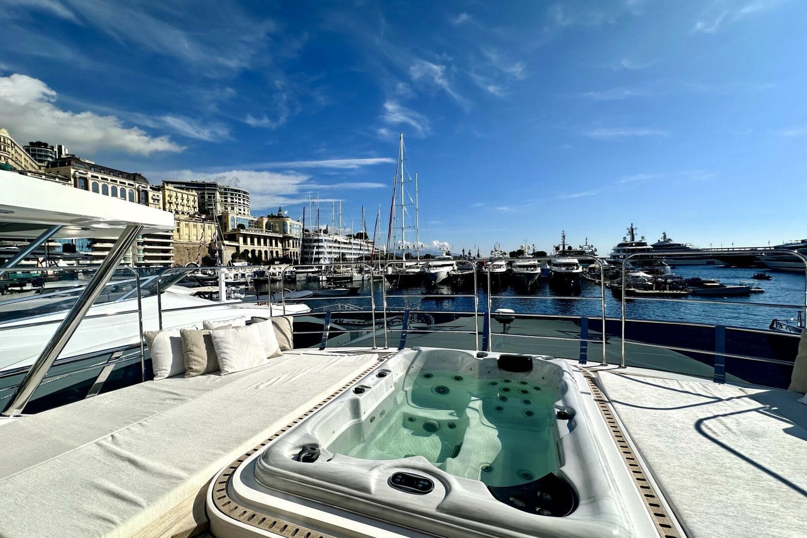 Luxurious 2023 Majesty 120 yacht with jacuzzi, docked in a scenic marina.