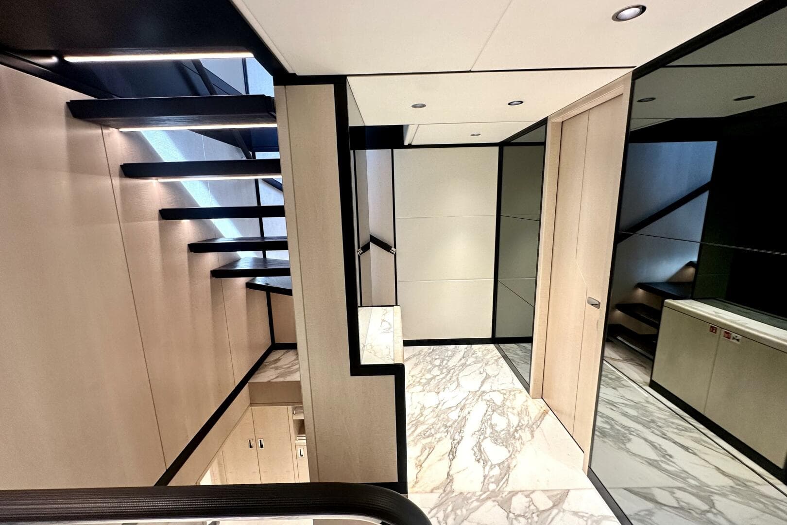Modern interior of 2023 Majesty 120 yacht with sleek staircase and marble flooring.