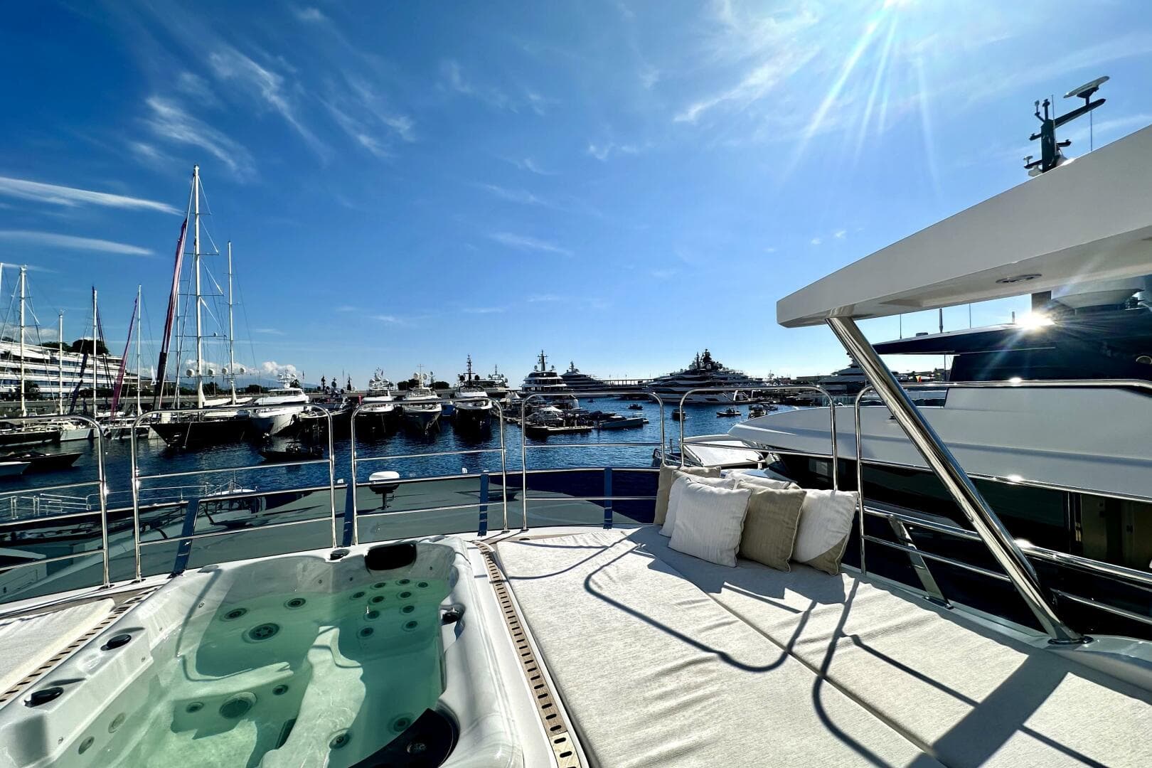 Luxurious 2023 Majesty 120 yacht with jacuzzi and sun deck, overlooking marina.