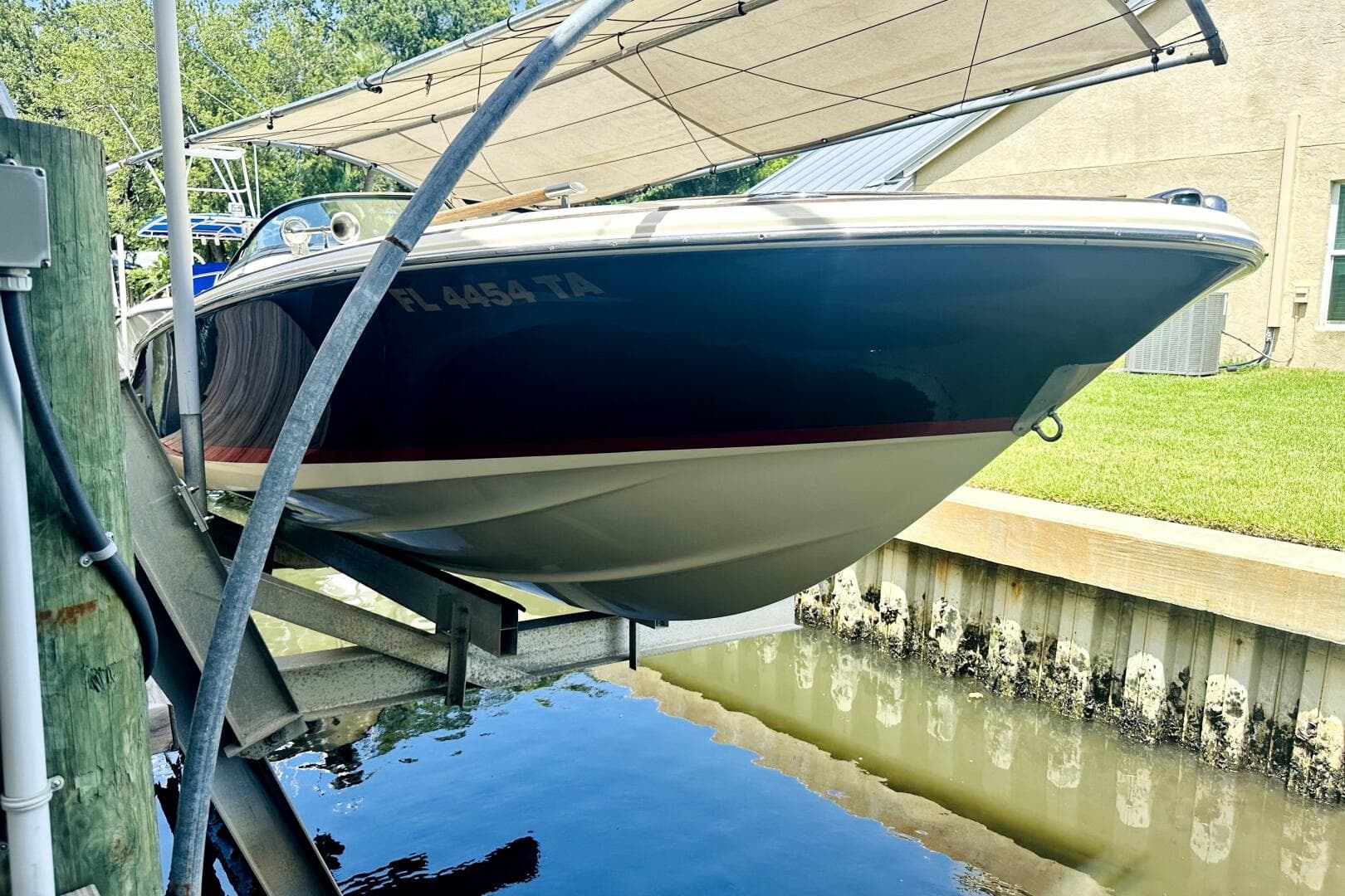 2013 Chris-Craft Corsair 22 boat docked, partially covered, with registration FL 4454 TA.