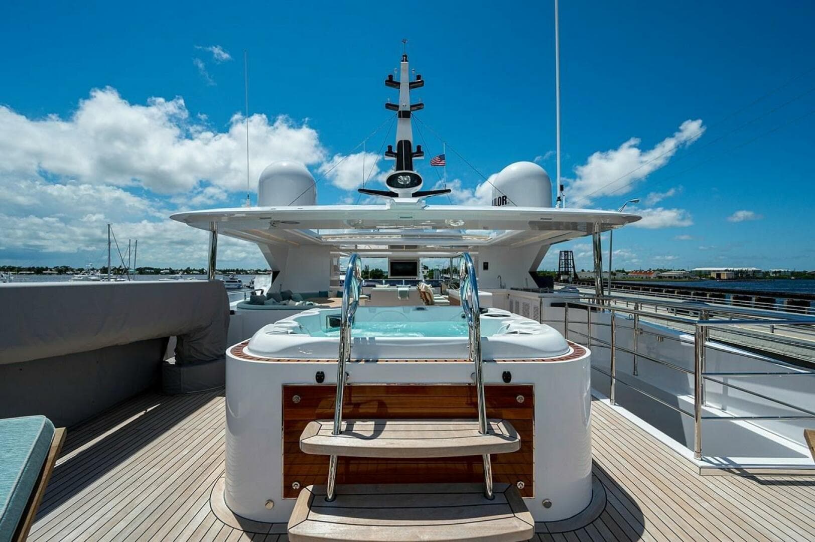 Luxury Majesty 140 yacht deck with jacuzzi, 2020 model, under clear blue sky.