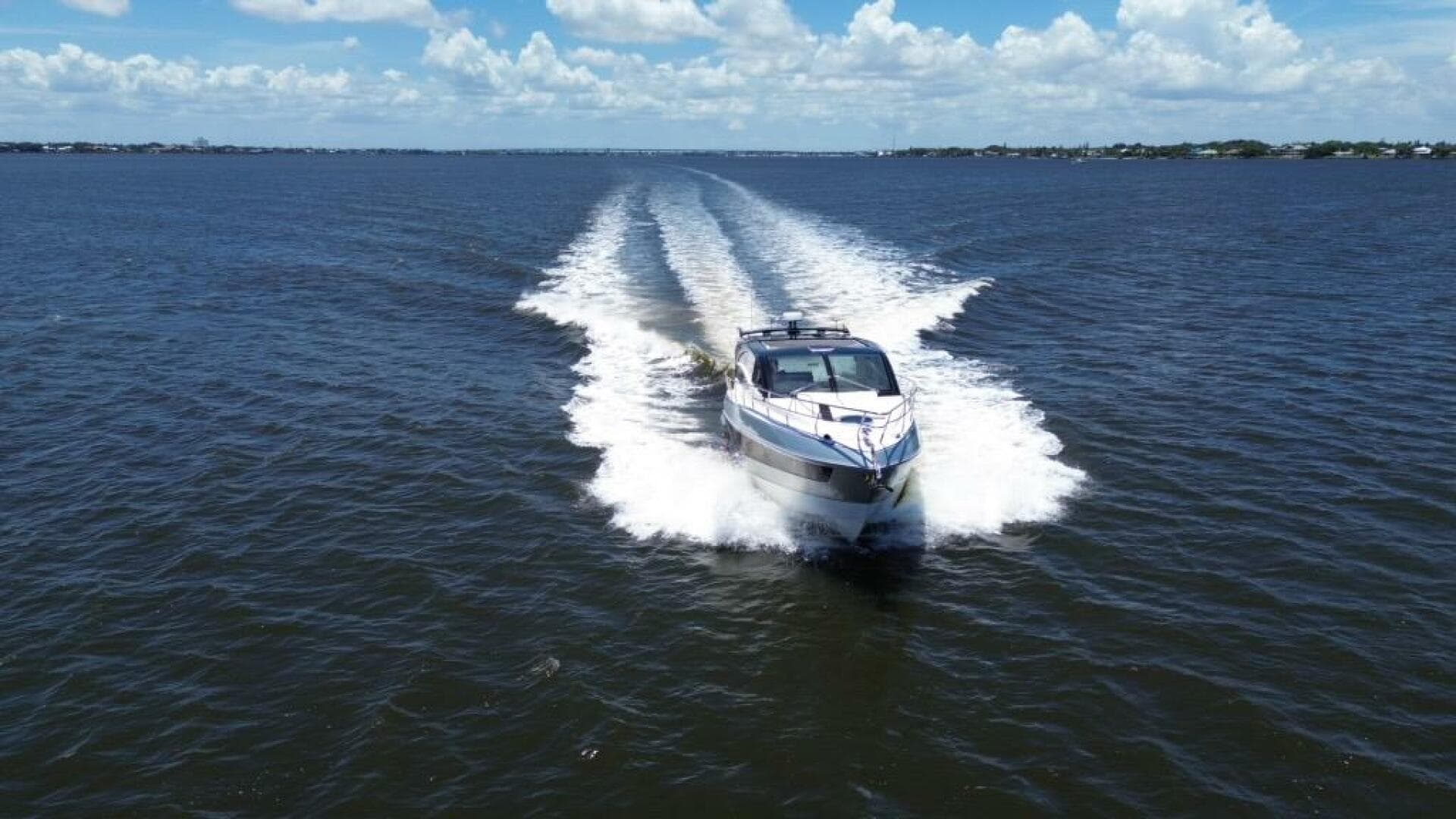 Luxury yacht Real 40 HT 2025 cruising on open water under blue skies.