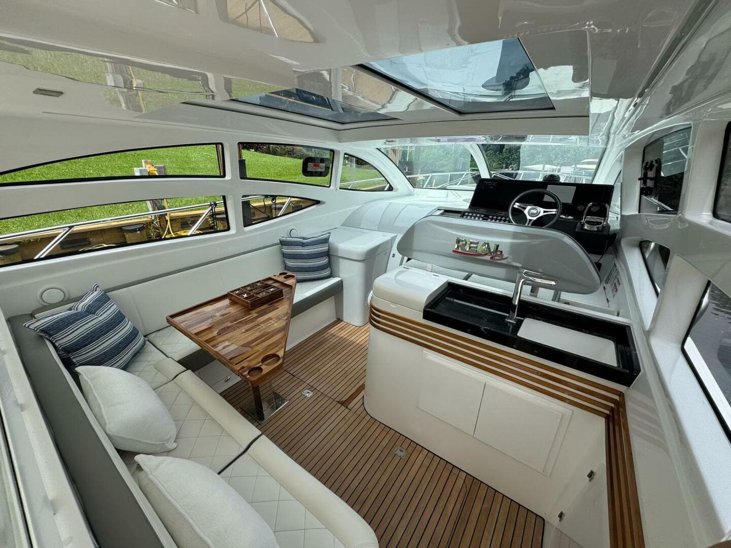 Luxurious interior of 2025 Real 40 HT yacht with elegant seating and modern helm.