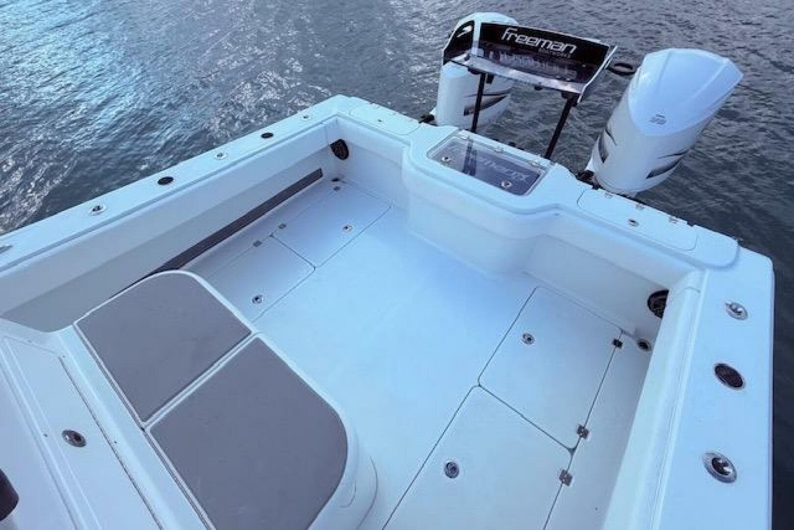 2019 Freeman 34 boat deck with dual engines on calm water.