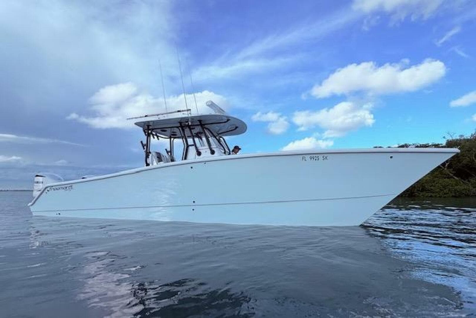 2019 Freeman 34 boat on calm water under a partly cloudy sky.