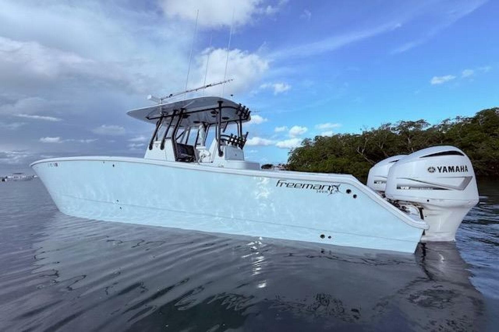 2019 Freeman 34 boat with Yamaha engines on calm water.