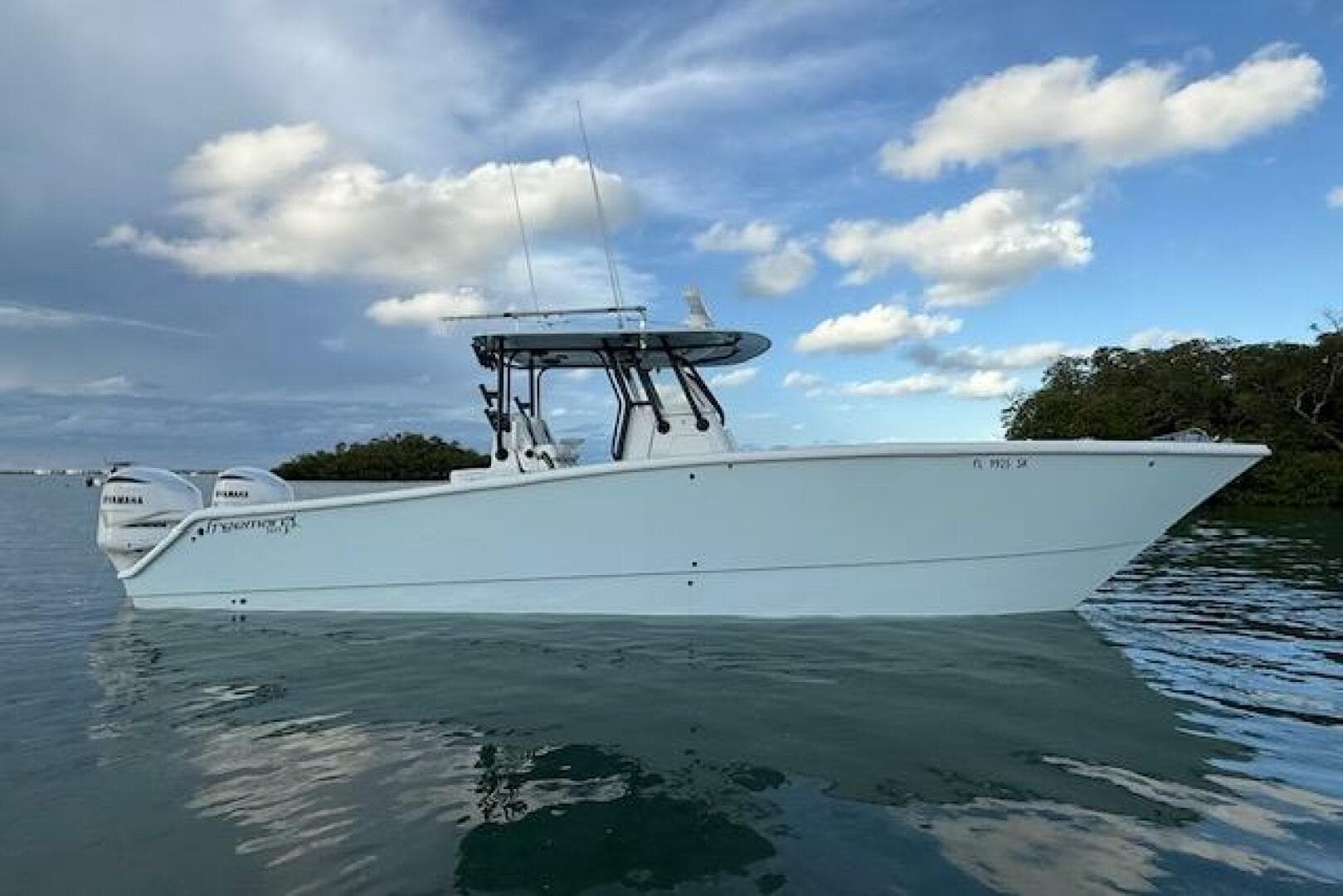 2019 Freeman 34 boat on calm water under a partly cloudy sky.